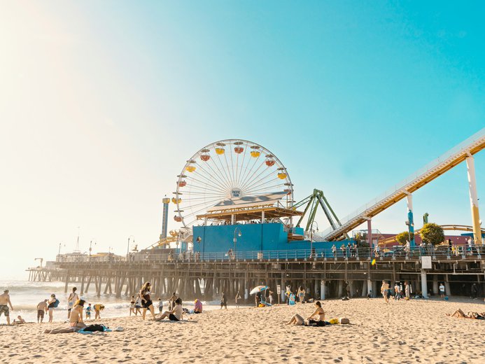 Santa Monica beach pier and ferris wheel with lots of people enjoying a sunny day there