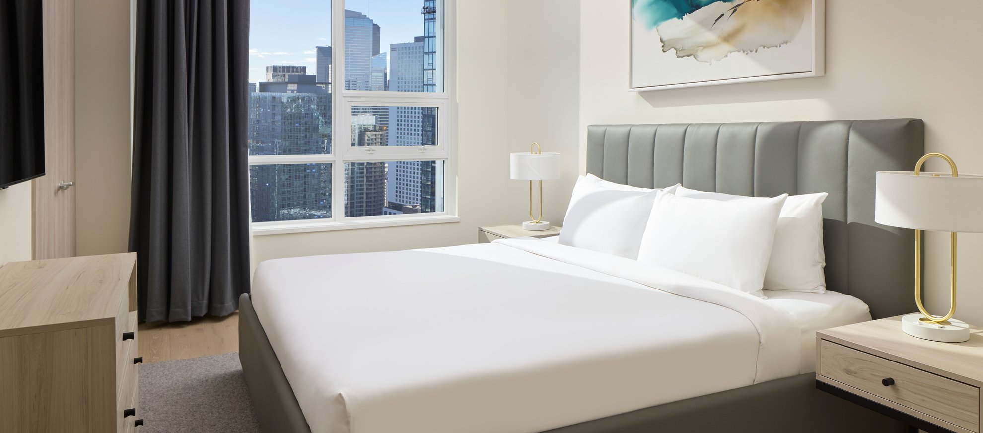 modern bedroom in the penthouse features king bed, wall art and large window with city view at level seattle south lake union.jpg